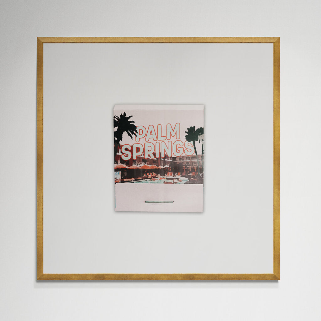 Palm Springs matchbook print in gold frame on wall