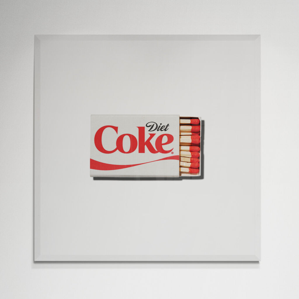 Diet Coke matchbox print in white frame on kitchen wall