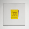 Waffle House matchbook print in white frame on kitchen wall