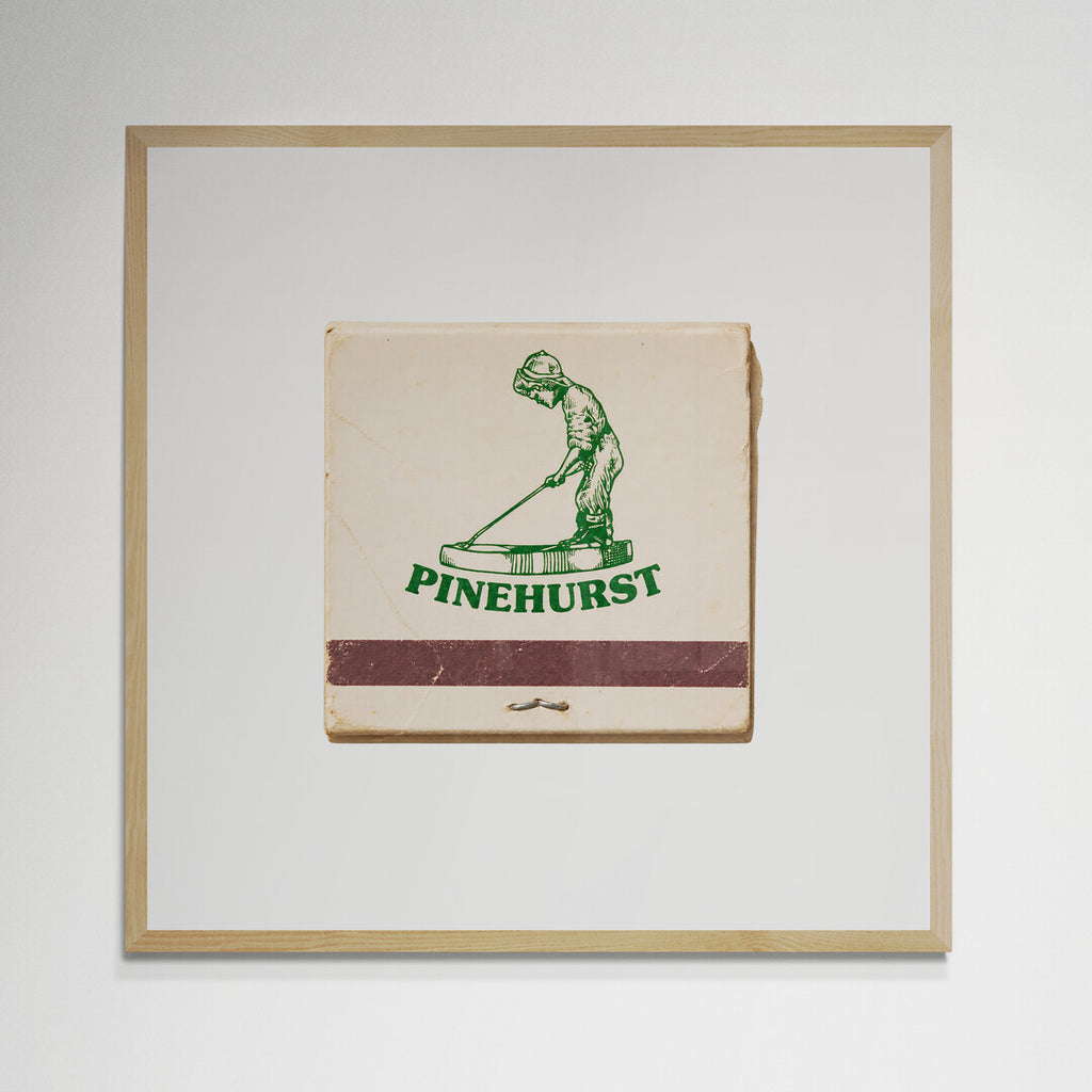 Pinehurst golf matchbook print in natural wood frame on wall