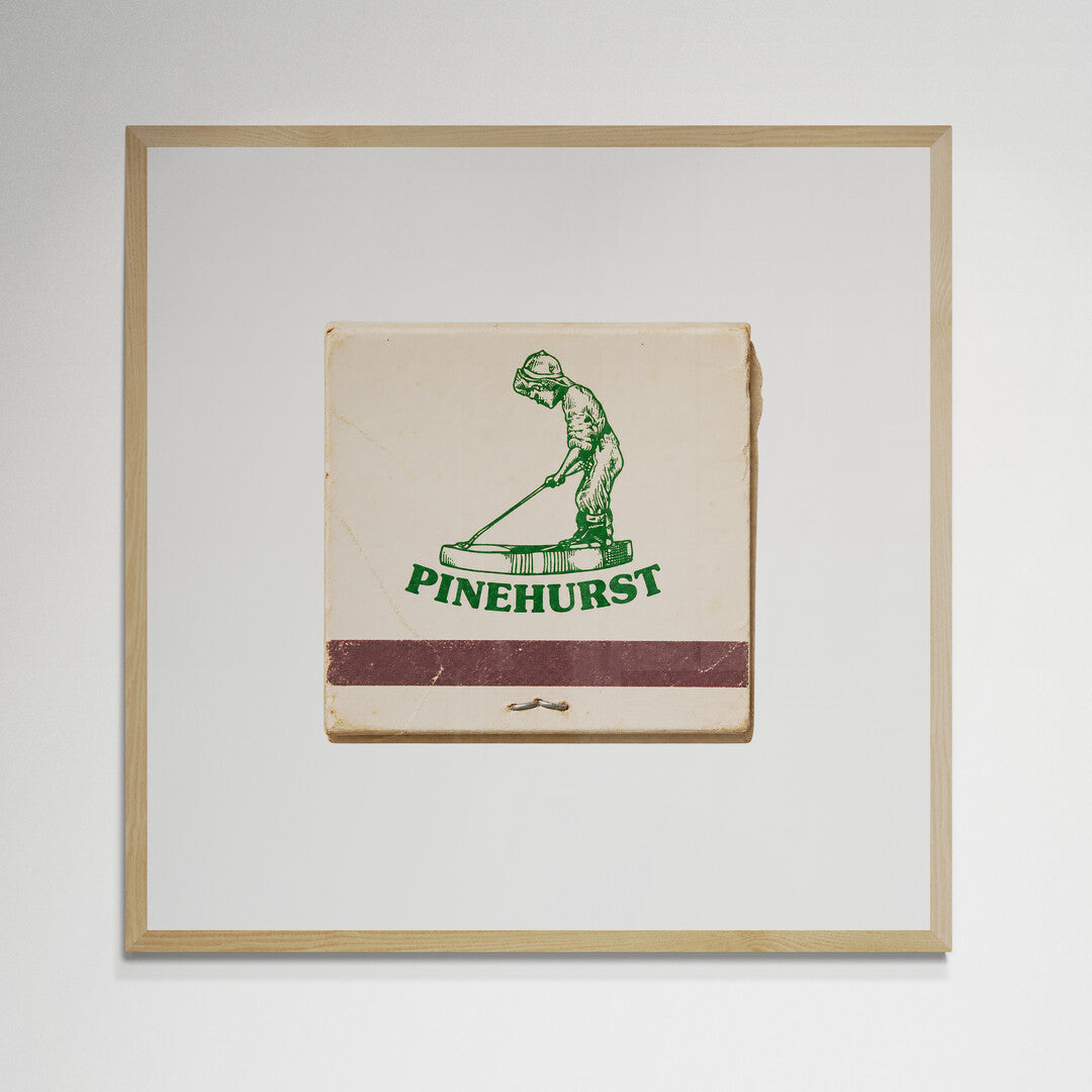 Pinehurst golf matchbook print in natural wood frame on wall